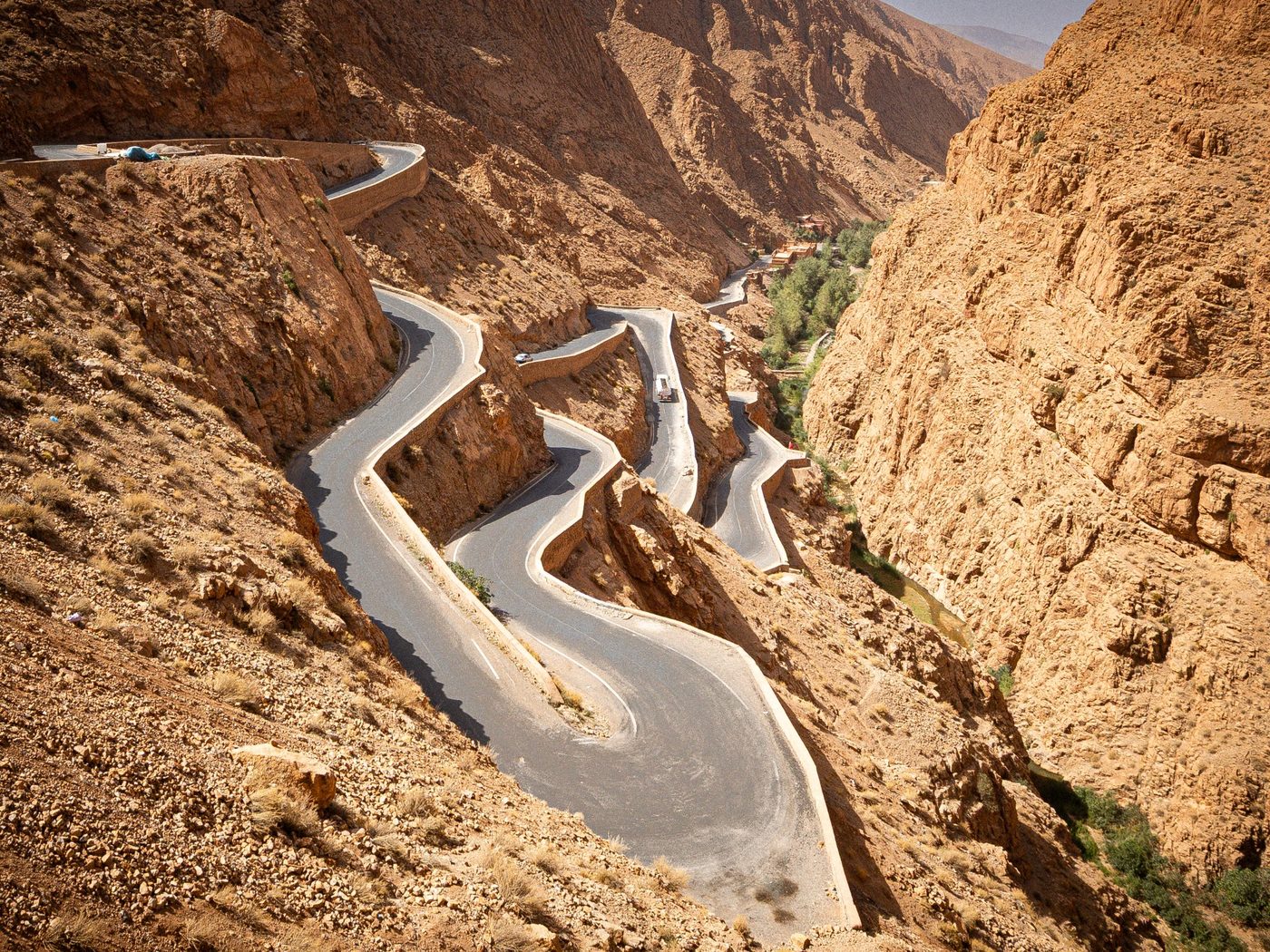 A winding road crossing a rocky desert canyon